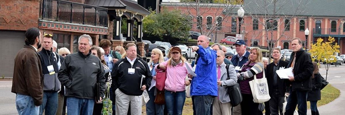 LIAA's Former Executive Director Harry Burkholder Leads a Trail Towns Tour A group of people take a tour of a downtown area